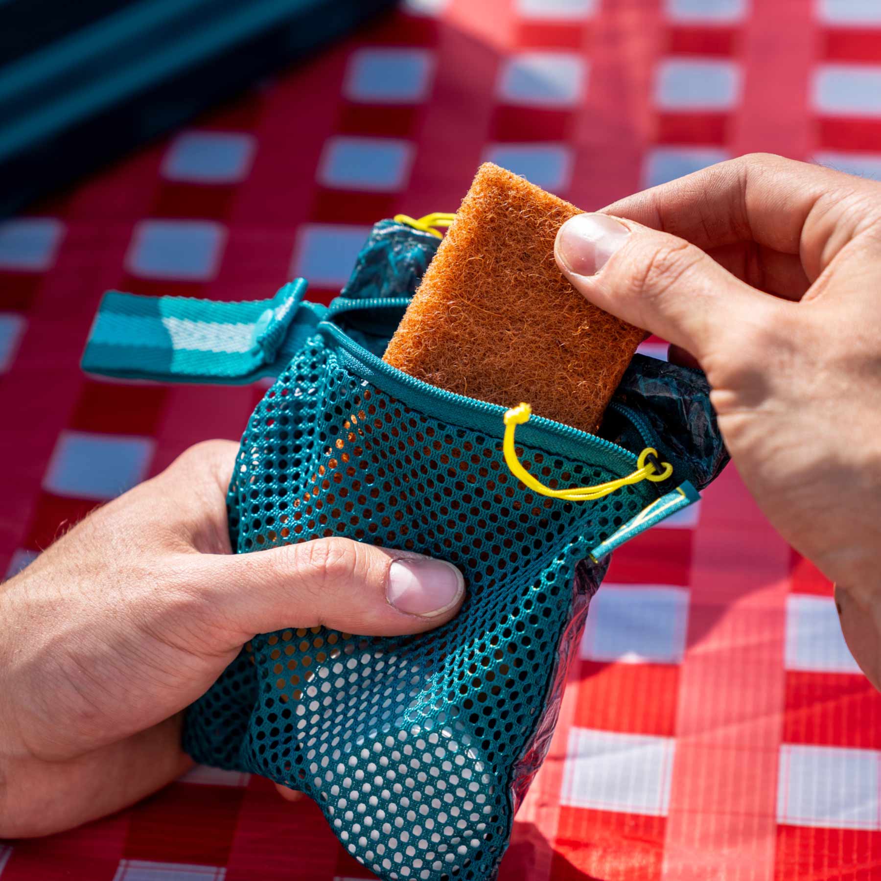 A person pulling out the coconut scrubber from the Adventure Ready Scrub and Dry kit.