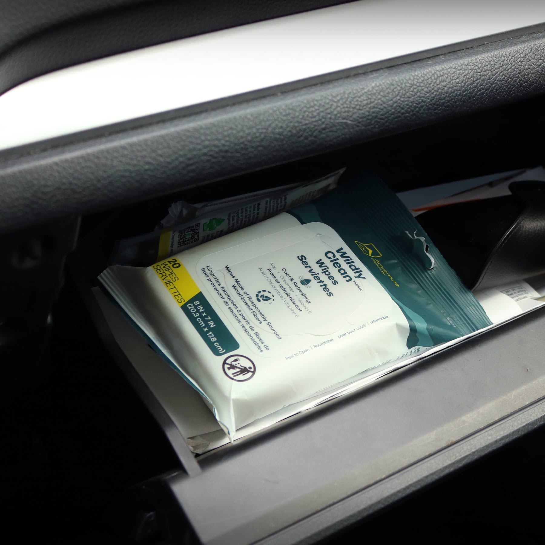A pack of the Wildly Clean Body Wipes in a car glove box.