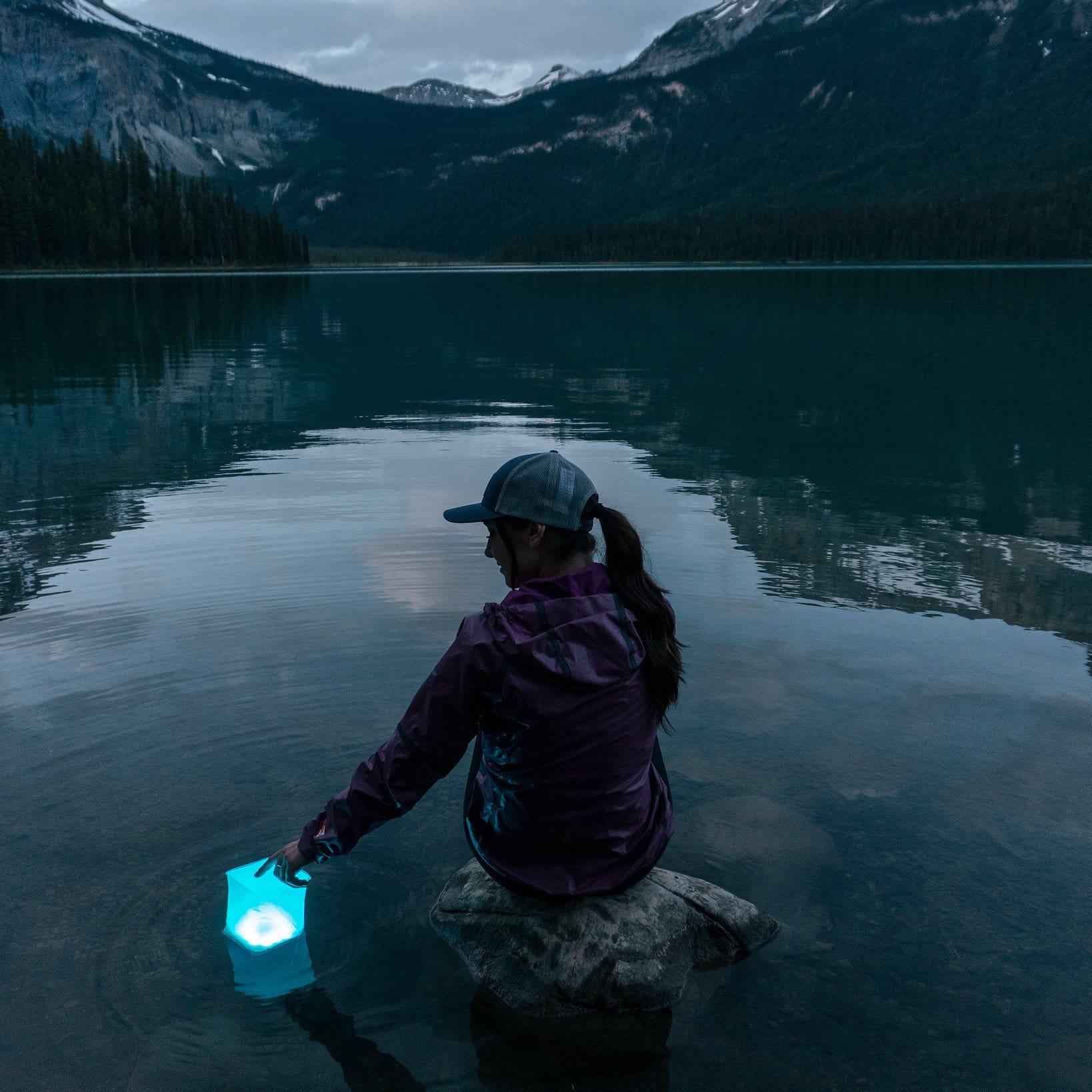 Woman on Lake floating her solar Lantern-PackLite Spectra USB.