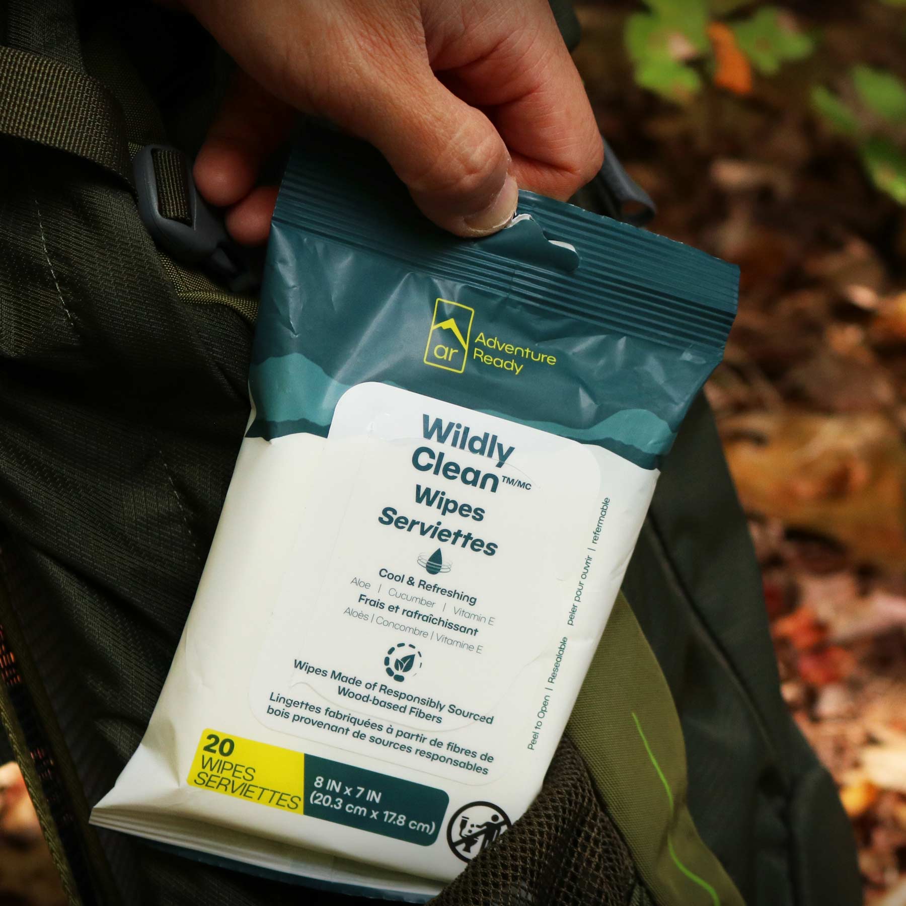 Image shows a pack of Wildly Clean Wipes being pulled out from the side of a backpack.